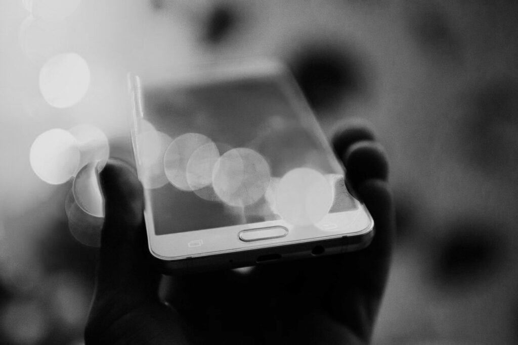 Black and white photo of a smartphone with bokeh light effects